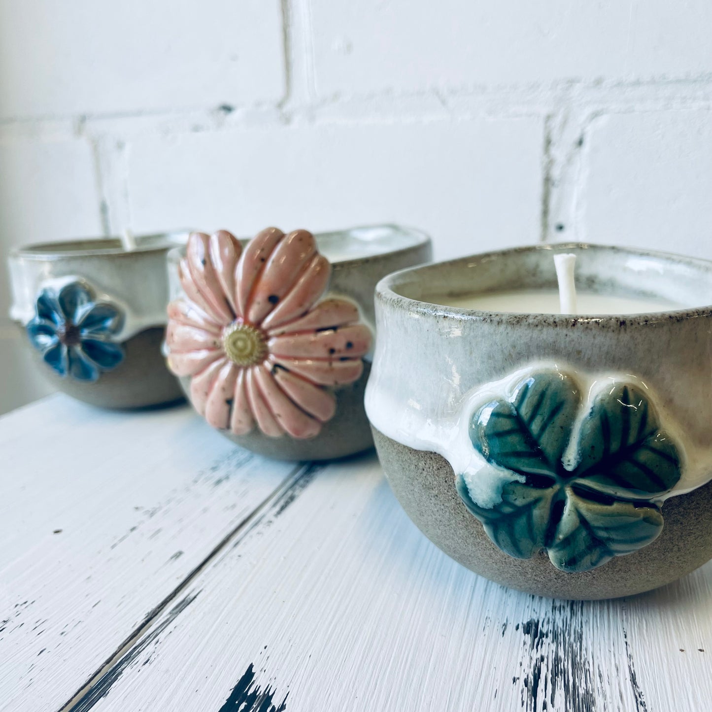Handgemachte Kerze in Keramiktasse mit Blüten-Relief, Steinzeugkeramik, Bienenwachskerze
